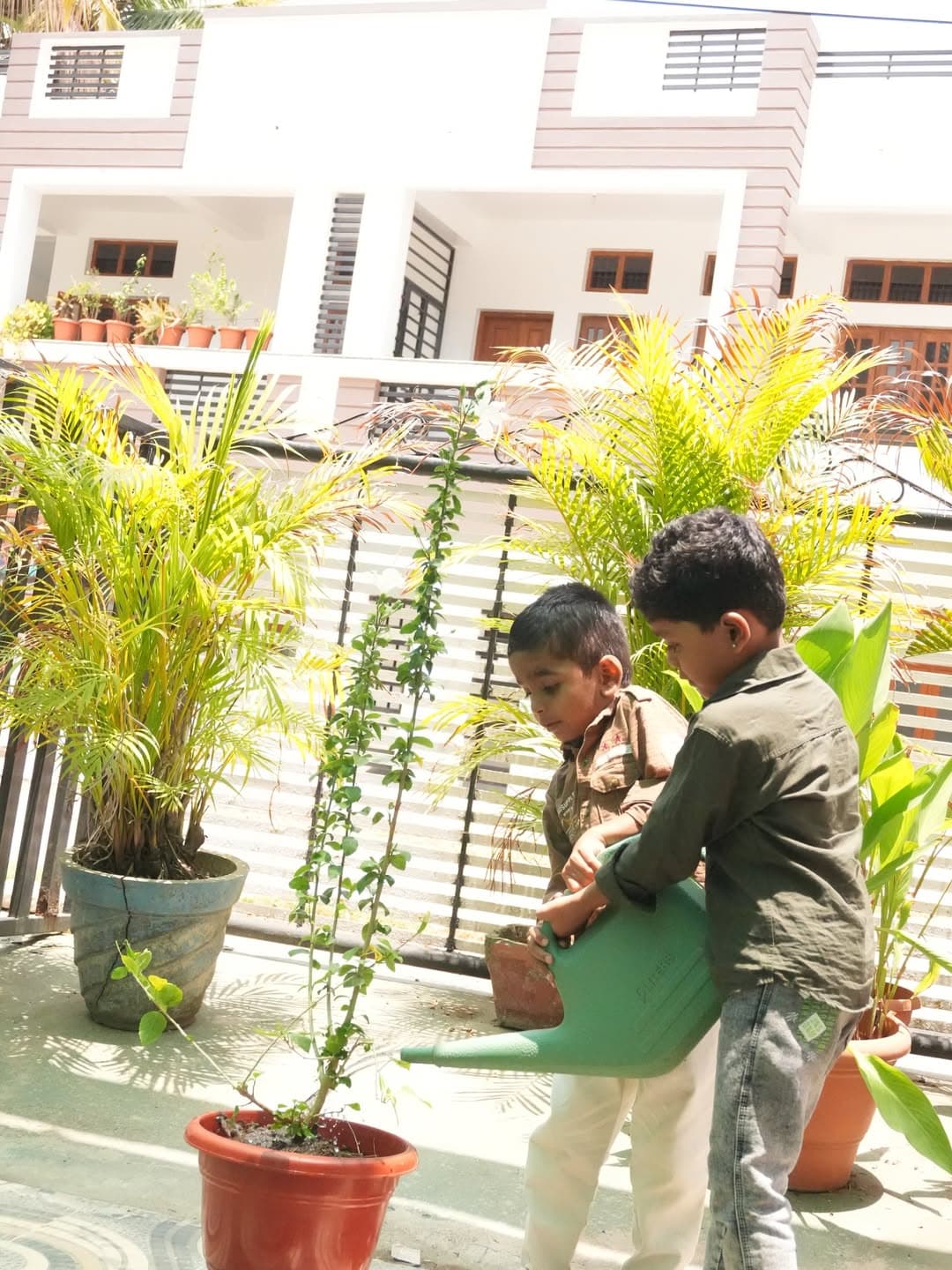 Two children watering a sapling during a hands-on gardening activity.