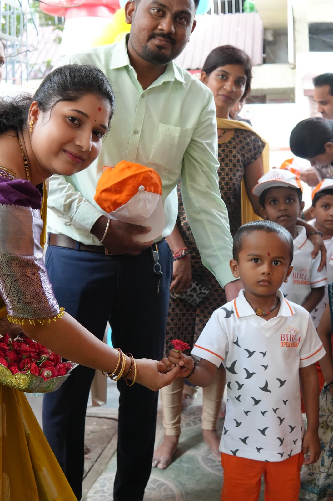 A teacher welcoming a new student with flowers on the first day.